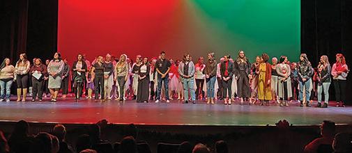 以红、绿、黑为背景，满是表演者的室内剧场舞台